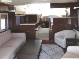 A spacious and elegantly designed interior of a yacht, featuring comfortable seating and a well-appointed cabin area, perfect for relaxing during a cruise.