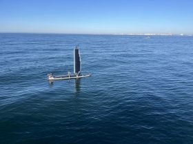 A sleek solar-powered boat glides across calm waters, showcasing innovative marine technology in action.