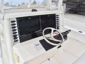 A detailed view of the helm and console area inside a boat, showcasing the navigation equipment and steering wheel, ideal for boating enthusiasts and potential buyers.