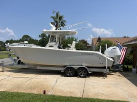 A Cobia boat is showcased on its trailer, parked in a residential area, highlighting its sleek design and readiness for water adventures.