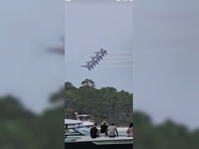 A thrilling airshow featuring precision flying by jets, with spectators enjoying the view from their boats — a perfect day on the water.