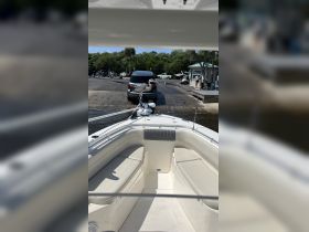 A heron perches on the bow of a boat at a ramp, showcasing a unique interaction between wildlife and boating activities.