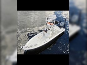 Aerial view of a sleek center console boat cruising on calm waters, showcasing its design and functionality for fishing or leisure outings.