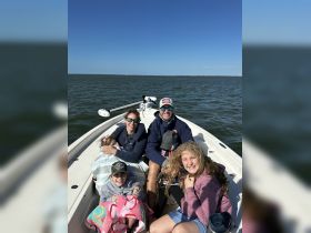 A joyful family enjoys a day on the water, capturing smiles and togetherness aboard their boat — perfect for family outings and adventures.
