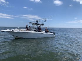 A group enjoys a day of fishing on a boat in the ocean, showcasing the fun and camaraderie of a fishing trip.