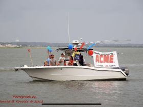 A lively group celebrates aboard a boat decorated for an event, showcasing community spirit and fun on the water.