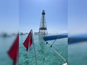 A stunning view of a lighthouse standing tall over crystal-clear waters, perfect for capturing the beauty of coastal adventures.