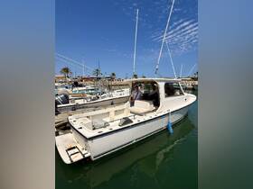 A well-maintained boat docked at the marina, showcasing its structure and design with a crew member onboard, perfect for fishing or leisure trips.