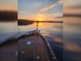 A serene sunset view from the bow of a boat, reflecting on calm waters — perfect for peaceful evening cruises.