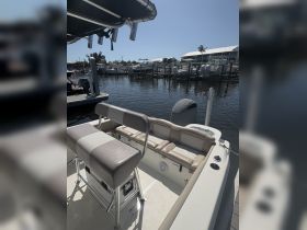 Interior view of a boat's helm and seating area, showcasing comfortable seating and a well-equipped console, perfect for a day on the water.
