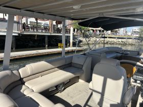 Interior view of a spacious pontoon boat featuring comfortable seating, perfect for relaxing on the water or entertaining guests.