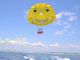 Thrilling parasailing adventure with two participants soaring high above the water, enjoying breathtaking views and a fun-filled day on the sea.