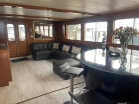 Interior view of a stylish boat cabin featuring comfortable seating and a dining area, perfect for relaxing and entertaining while on the water.