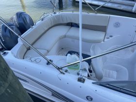 Interior view of a boat's seating and helm area, showcasing comfortable lounge space and storage options, perfect for relaxing on the water.