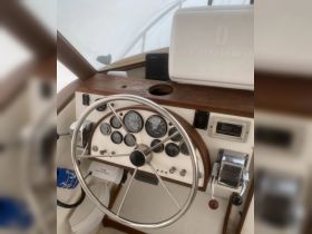 A detailed view of the helm and console inside a boat, showcasing the steering wheel and various gauges — perfect for understanding the boat's navigation and control systems.