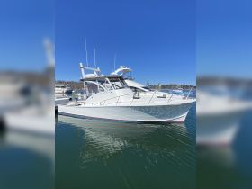 A stunning yacht docked at the marina, showcasing its sleek design and pristine condition against a clear blue sky.
