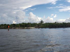 A scenic view of a waterway with clouds and vegetation, but the image lacks clarity and detail.