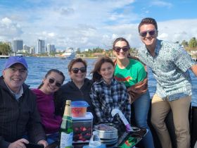 A joyful family gathers on a boat, enjoying a day out on the water with snacks and smiles — perfect for creating lasting memories together.