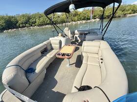 A spacious interior view of a pontoon boat featuring comfortable seating and a lounge area, perfect for relaxing on the water.