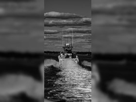 A boat speeds through the water, leaving a wake behind, showcasing an exciting day on the water.