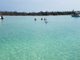 A group enjoys a fun day in the clear waters, perfect for swimming and relaxation — an ideal beach experience.