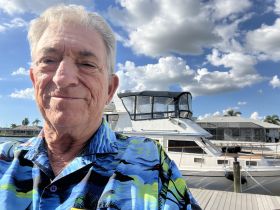 A cheerful selfie with a boat in the background, capturing a moment at the dock — perfect for showcasing boating adventures.