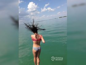 A young girl joyfully jumps into the clear waters, capturing the essence of summer fun and adventure on the water.