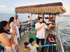 A lively group enjoys their time on a boat, engaging in playful activities and capturing memories together — perfect for family outings and celebrations on the water.
