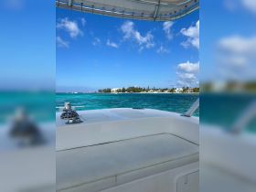 A serene view from the interior of a boat, showcasing comfortable seating and a clear turquoise sea in the background — perfect for relaxing on the water.