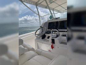 The interior view of a boat's helm and seating area, showcasing the modern console and comfortable seating, perfect for navigating the open waters.