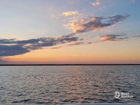 A serene sunset over calm waters, showcasing the beauty of nature — perfect for tranquil boating experiences.