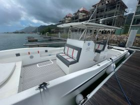 Interior view of a spacious boat featuring comfortable seating and a helm, perfect for relaxing on the water.