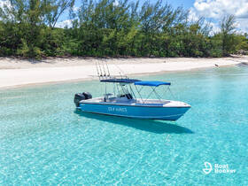A stunning view of the 'Sea Winnings' boat anchored in crystal-clear waters, surrounded by a serene beach and lush greenery — perfect for a day of relaxation on the water.