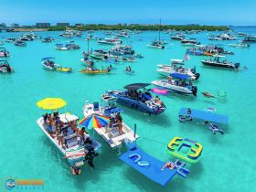 A vibrant scene of boaters enjoying a lively day at the sandbar, complete with swimming, lounging on floats, and socializing under the sun — a perfect summer getaway.