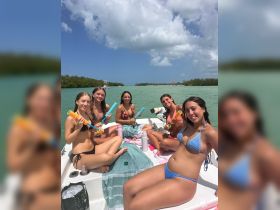 A lively group of friends enjoys a fun day on the boat, playing with colorful water toys and soaking up the sun — perfect for a memorable summer outing.