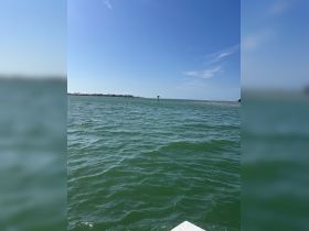 A view of the water with a distant landmass and a marker, but the image lacks clarity and focus.