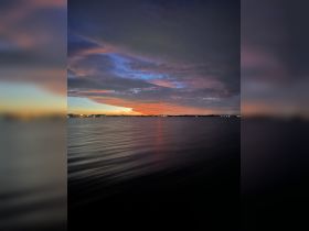 A stunning sunset over calm waters, showcasing vibrant colors and reflections — a perfect backdrop for evening boat trips or romantic getaways.