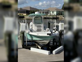 A pristine center console boat docked at a residential marina, showcasing its sleek design and ready for a day on the water.