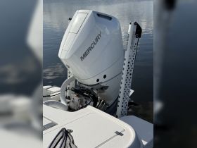 Close-up of a Mercury outboard engine mounted on a boat, showcasing essential boating equipment for performance and reliability on the water.