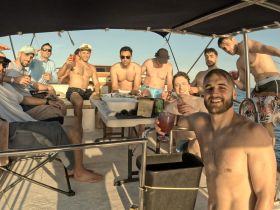 A lively group of friends enjoys drinks and camaraderie aboard a boat, capturing the essence of a fun day on the water.