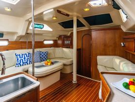 A cozy interior view of a boat cabin featuring comfortable seating and a dining area, perfect for relaxing during a sailing trip.