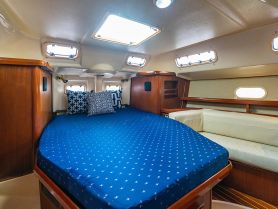 Cozy interior cabin of a boat featuring a comfortable bed and seating area, perfect for relaxing during your nautical adventures.