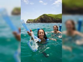 Two friends enjoy snorkeling in crystal-clear waters, showcasing the excitement of ocean adventures and group fun in a picturesque setting.