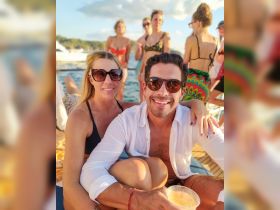 A joyful group of friends enjoys a lively party on a boat, capturing the essence of summer fun with cocktails and laughter.