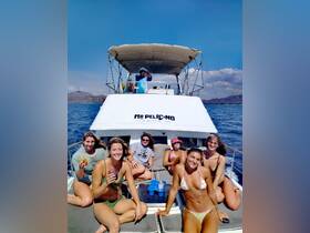 A lively group enjoys a fun-filled boat tour aboard 'Mr. Pelican,' capturing memories with drinks and smiles under the sun.
