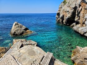 A stunning view of a rocky coastline with crystal-clear waters, perfect for exploring and enjoying the natural beauty of the area.