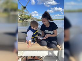 A mother and her young son enjoy a quiet moment inside the boat, looking at a book together — a perfect way to bond while on the water.