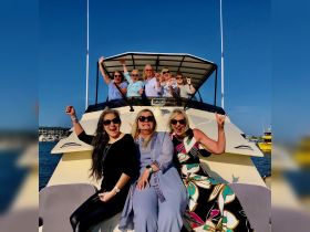 A lively group of women celebrates aboard a boat, showcasing joy and camaraderie against a beautiful backdrop — perfect for memorable outings and gatherings on the water.