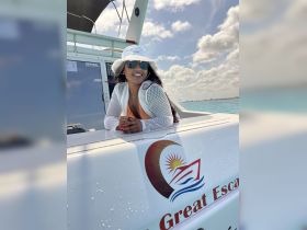 A woman enjoys a sunny day on a boat, showcasing a relaxed vibe with the ocean in the background — perfect for memorable boating adventures.