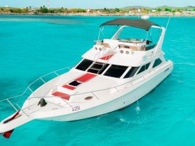 A stunning aerial view of a sleek yacht cruising through crystal-clear turquoise waters, perfect for luxury charters and island adventures.